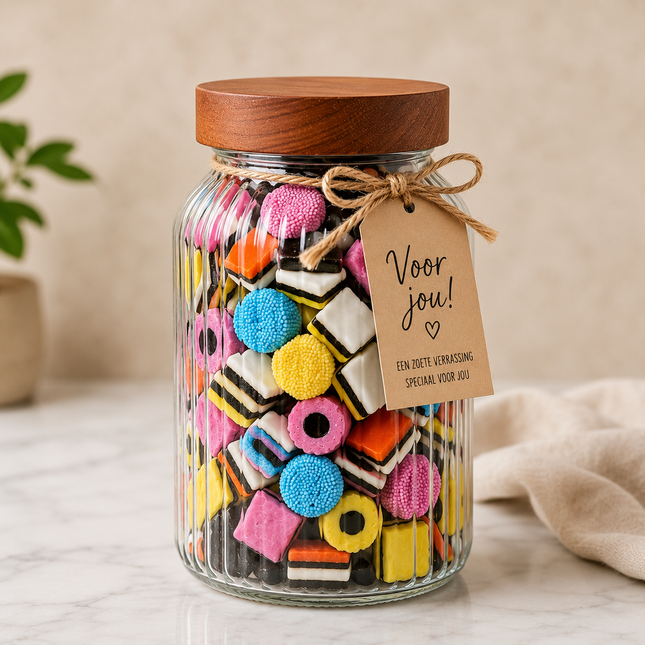 Luxe glazen snoeppot gevuld met Engelse drop en houten deksel met gepersonaliseerd cadeaukaartje.